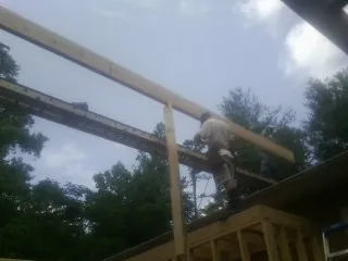 Carpenter setting a ridge beam over a new addition frame — Ice Dam Removal by Roofing Brothers in Fargo