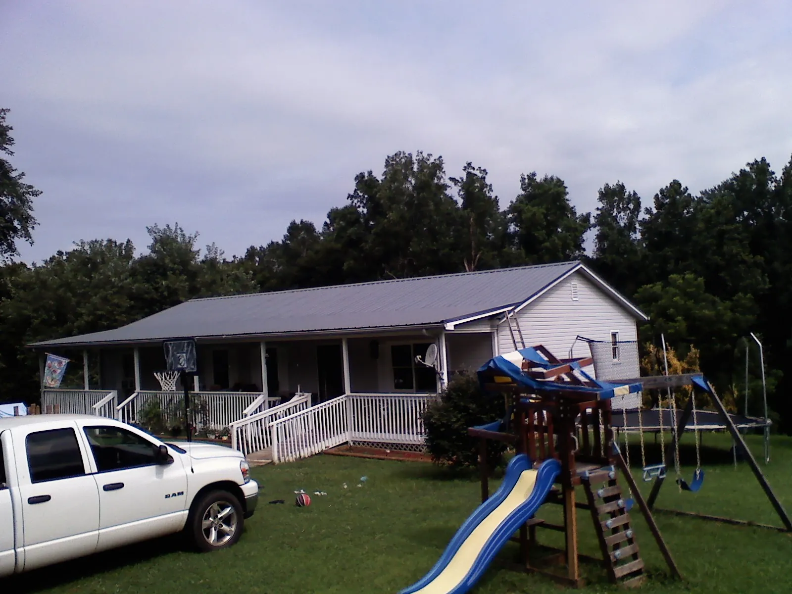 Dark metal roof on a country home with a full length front porch in Fargo