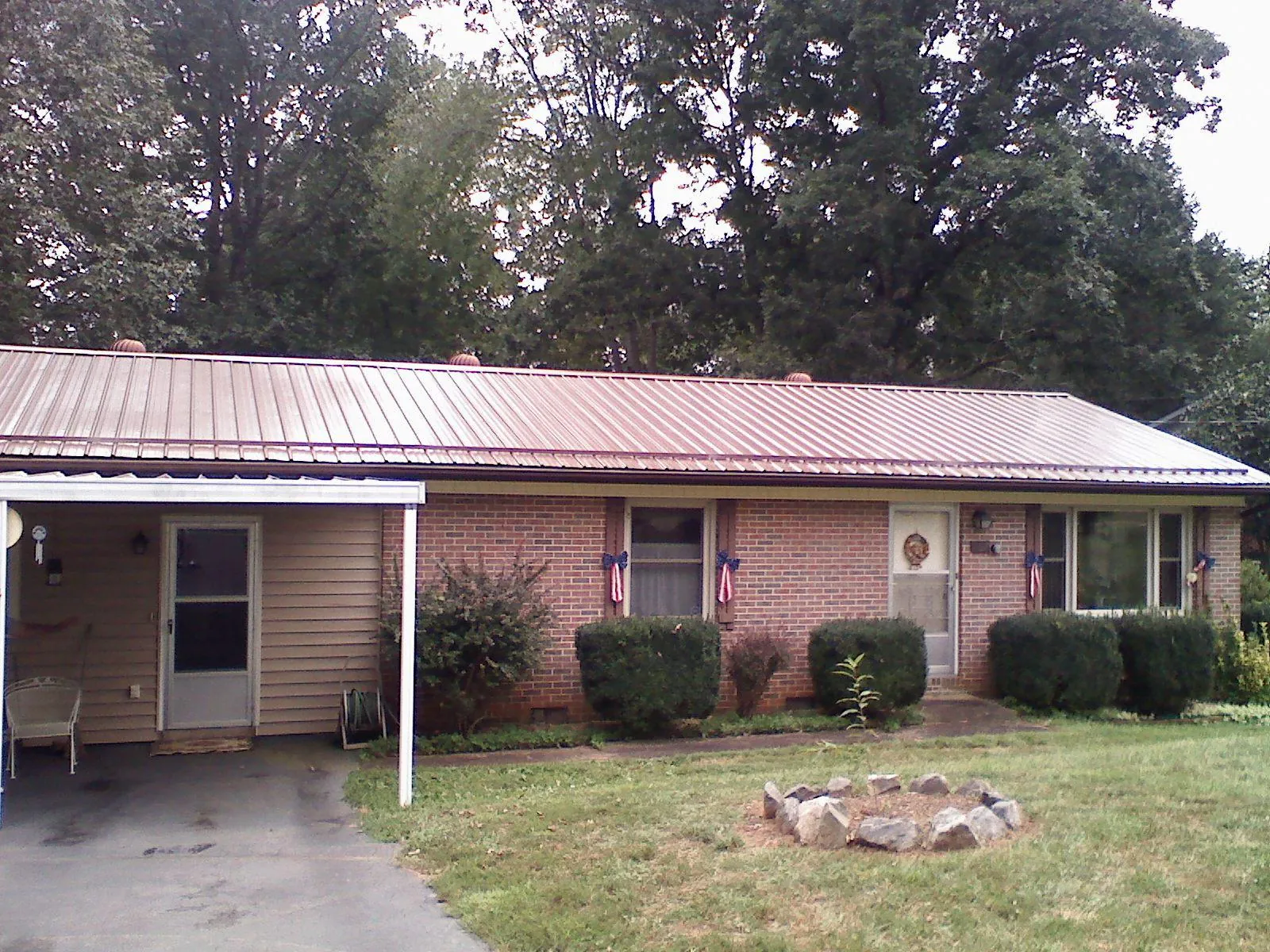 Bronze metal roof and carport on a brick ranch home — Roof Repair work by our crew in Fargo